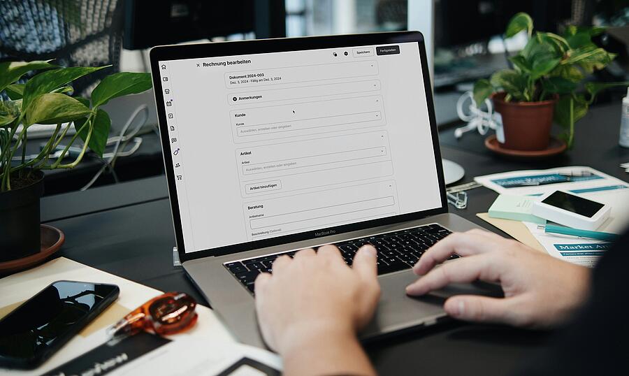 Ein aufgeklapptes Laptop an dem jemand sitzt und ein Formular bearbeitet.