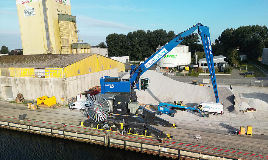 Bild des Kreishafen Rendsburg. Im Vordergrund die Kaikante an der das neue Umschlagsgerät steht und Kalk umschlägt. Neues Umschlagsgerät im Kreishafen Rendsburg