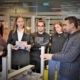 Ein Firmenmitarbeiter erklärt einer Gruppe von 6 Studenten des Institute of Technology an Innovation aus Sønderburg den Arbeitsprozess an einer Maschine.