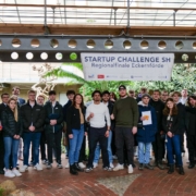 Das Foto zeigt eine größere Gruppe von Schülerinnen und Schülern des BBZ in Eckernförde im Foyer des Technik- und Ökologiezentrums. Sie haben an dem Regionalfinale der StartUp Challenge SH 2024 teilgenommen.